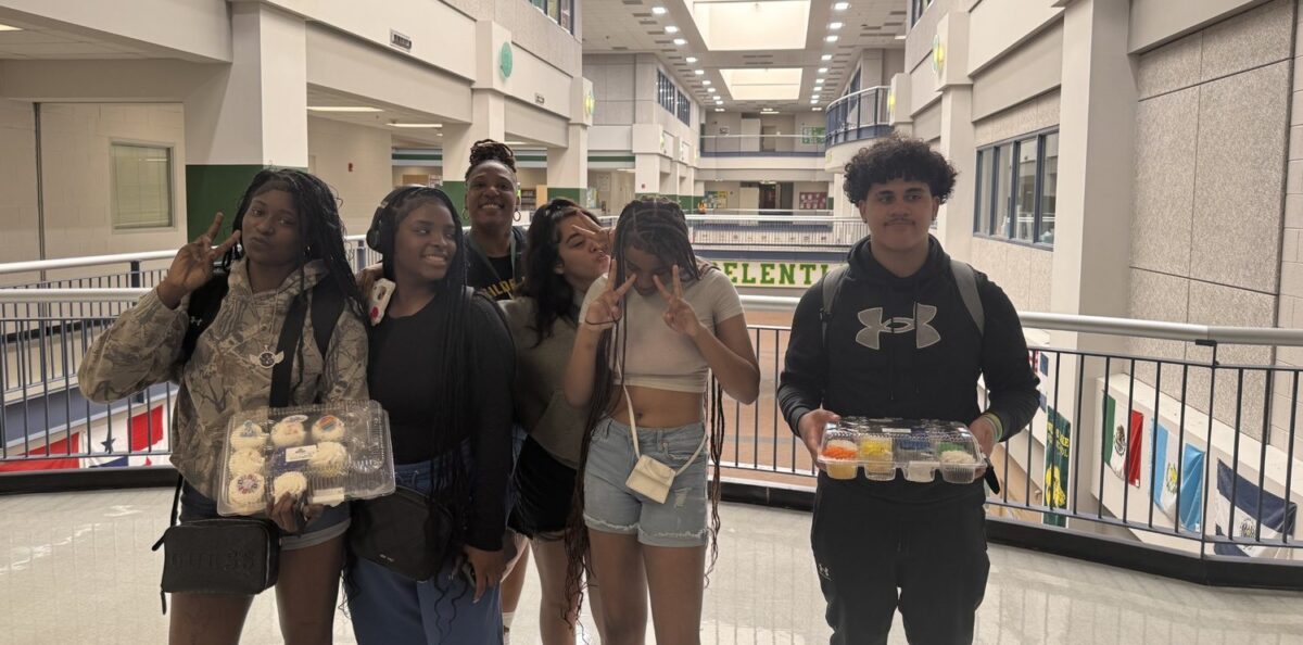 A group of OhanaHC students standing together and smiling in a school atrium.
