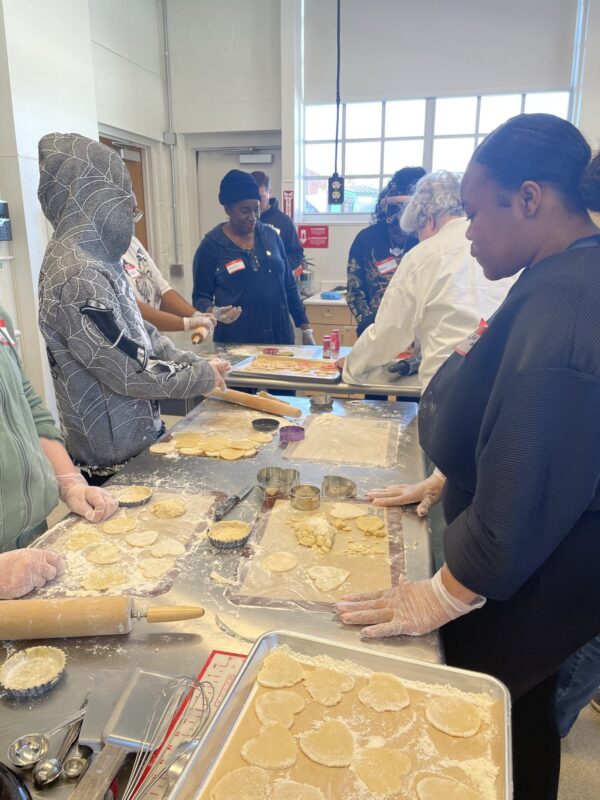 OhanaHC students and mentors rolling and cutting dough together at the Rolling Dough and Game Night event