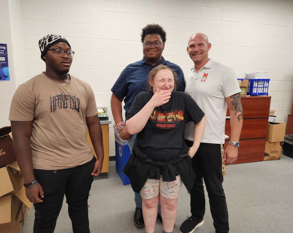 Three OhanaHC students and an adult mentor laughing together in a room at Hammond High School