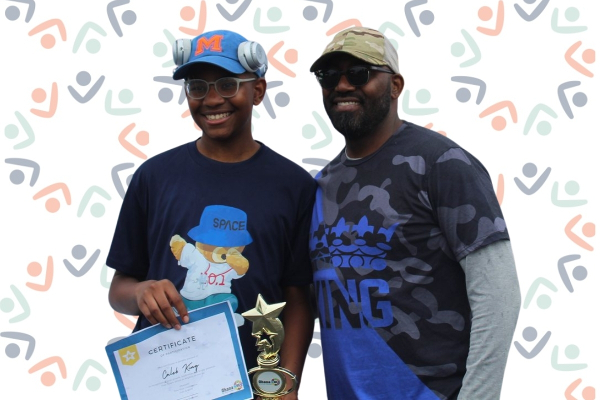 A Guilford Park student holding his certificate and star trophy beside his OhanaHC mentor, against an OhanaHC backdrop