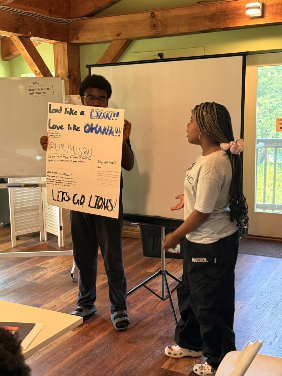 Two Howard High students presenting their hand-lettered poster, Lead like a Lion, Love like Ohana