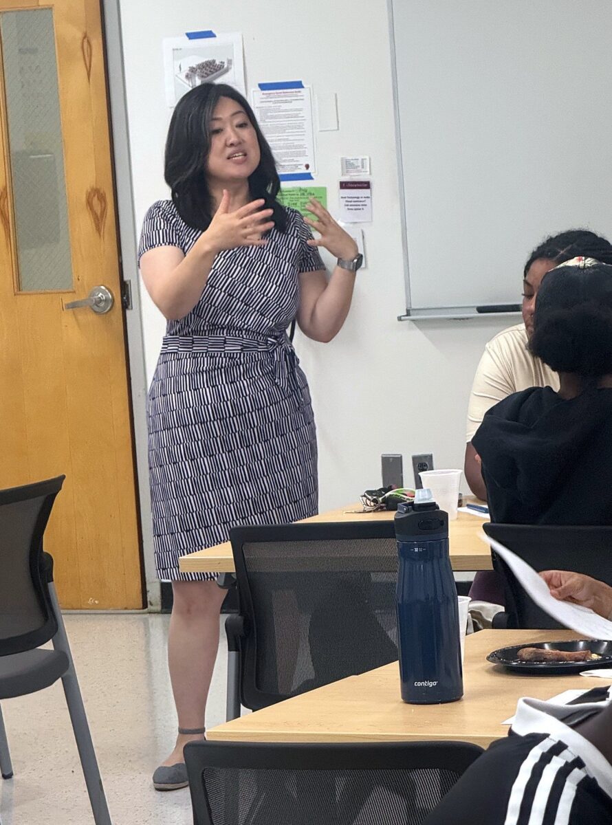 A facilitator speaking to seated participants at a Pathfinders session