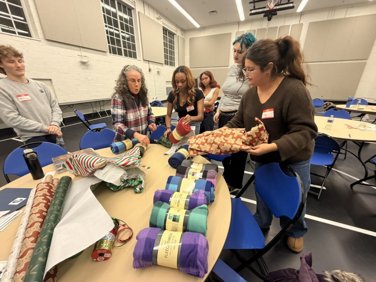 Pathfinders and their mentors wrapping gifts together at the Pathfinders holiday party