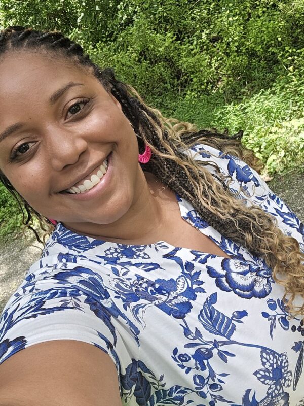 Taylor Ellerbe smiling outdoors, with trees behind her