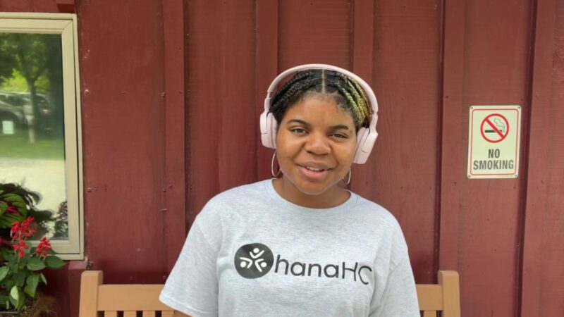 A student in an OhanaHC shirt pitching the OhanaHC Shark Tank outside a red barn