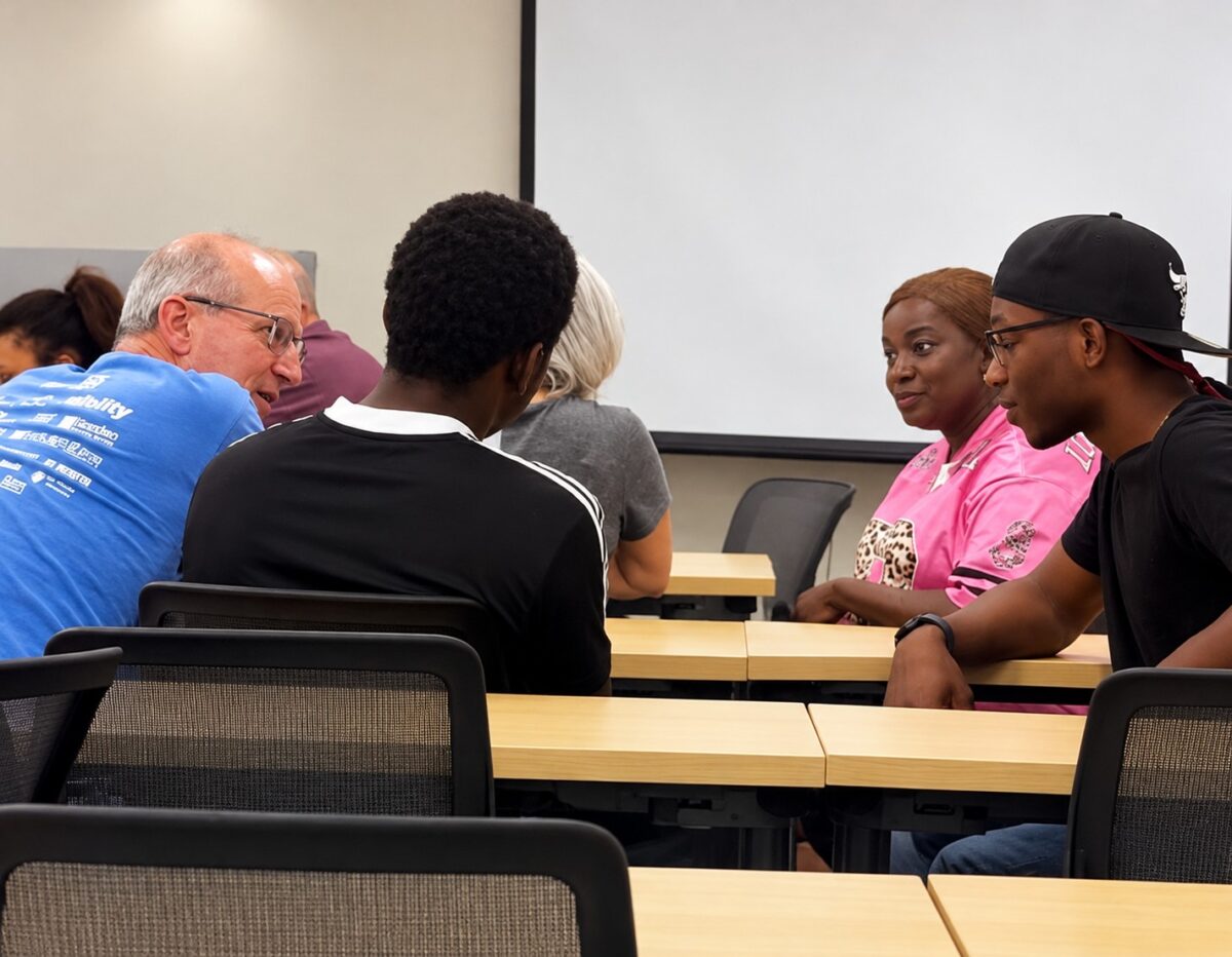 Students and mentors leaning in across a table in conversation at an OhanaHC session
